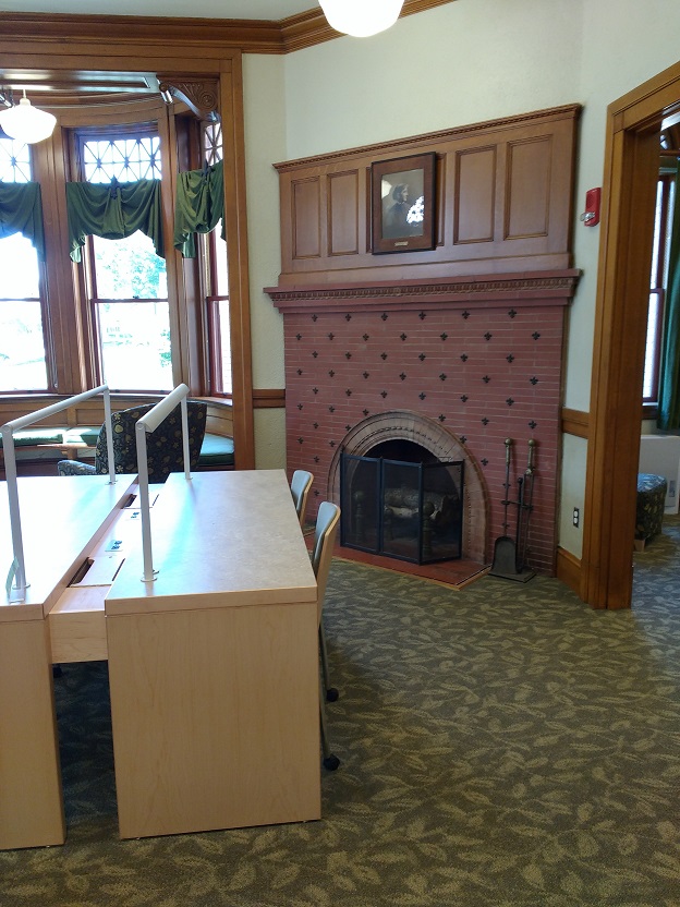 fireplace flanked by the window seating and a large desk