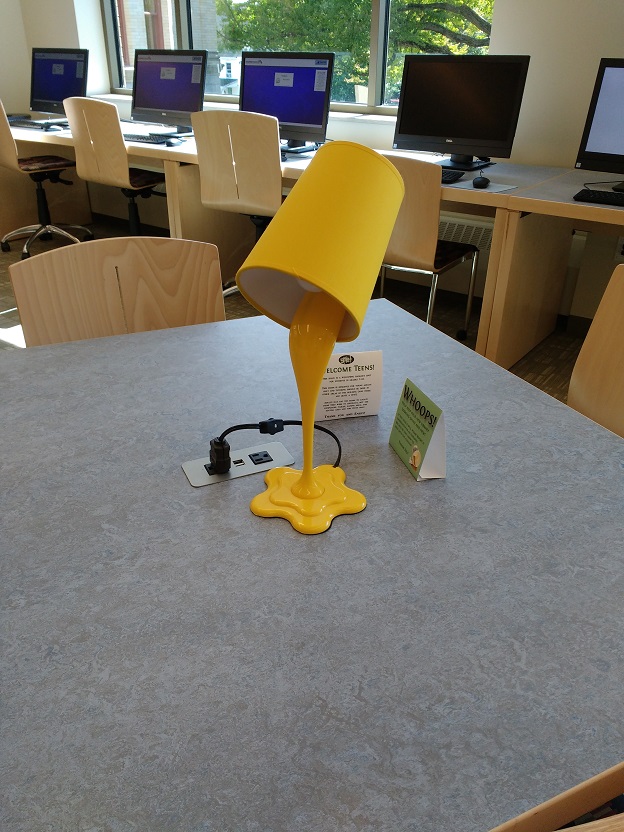 a yellow lamp with a flower-shaped bottom and curvy design details