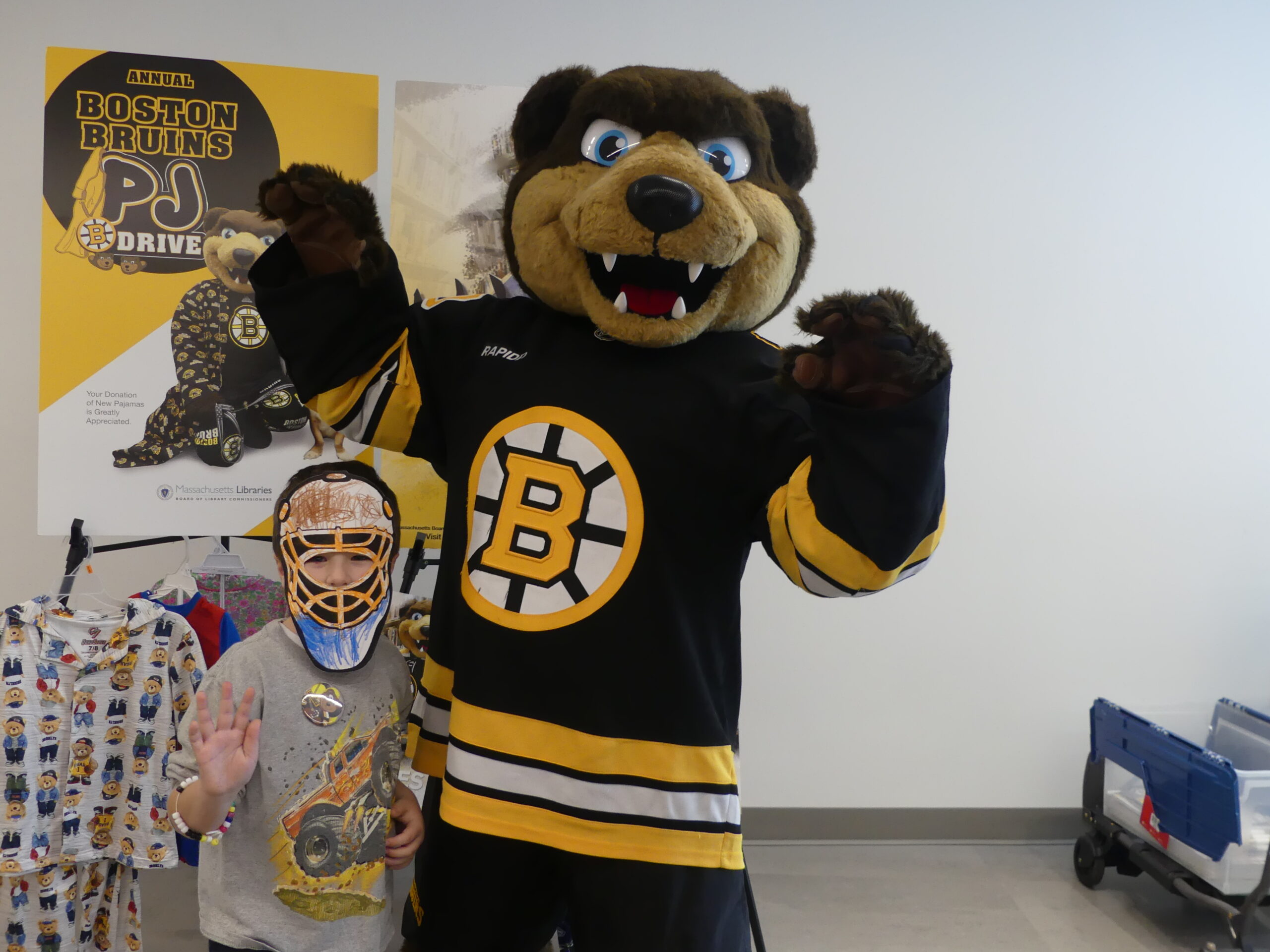 Young Bruins fan poses with Bruins Mascot Blades at a Boston Bruins PJ Drive event at the Sawyer Free Library in Gloucester
