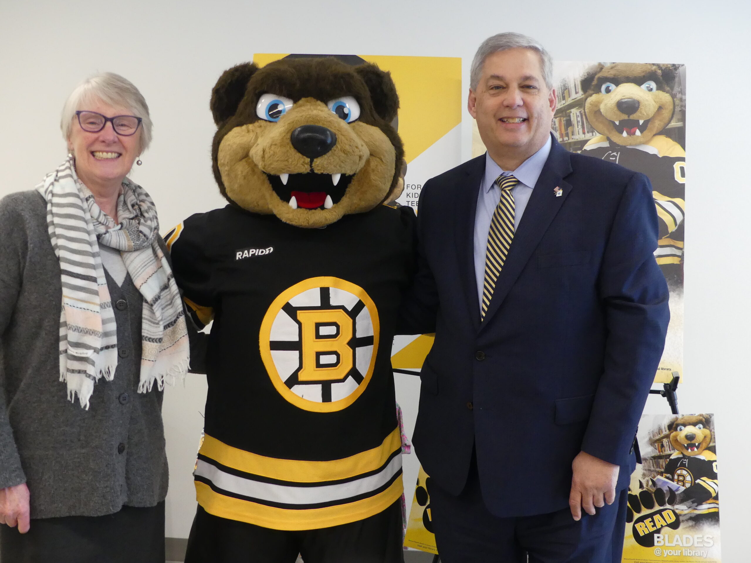 Jenny Benedict, Director of the Sawyer Free poses with Bruins Mascot Blades and Senator Bruce Tarr
