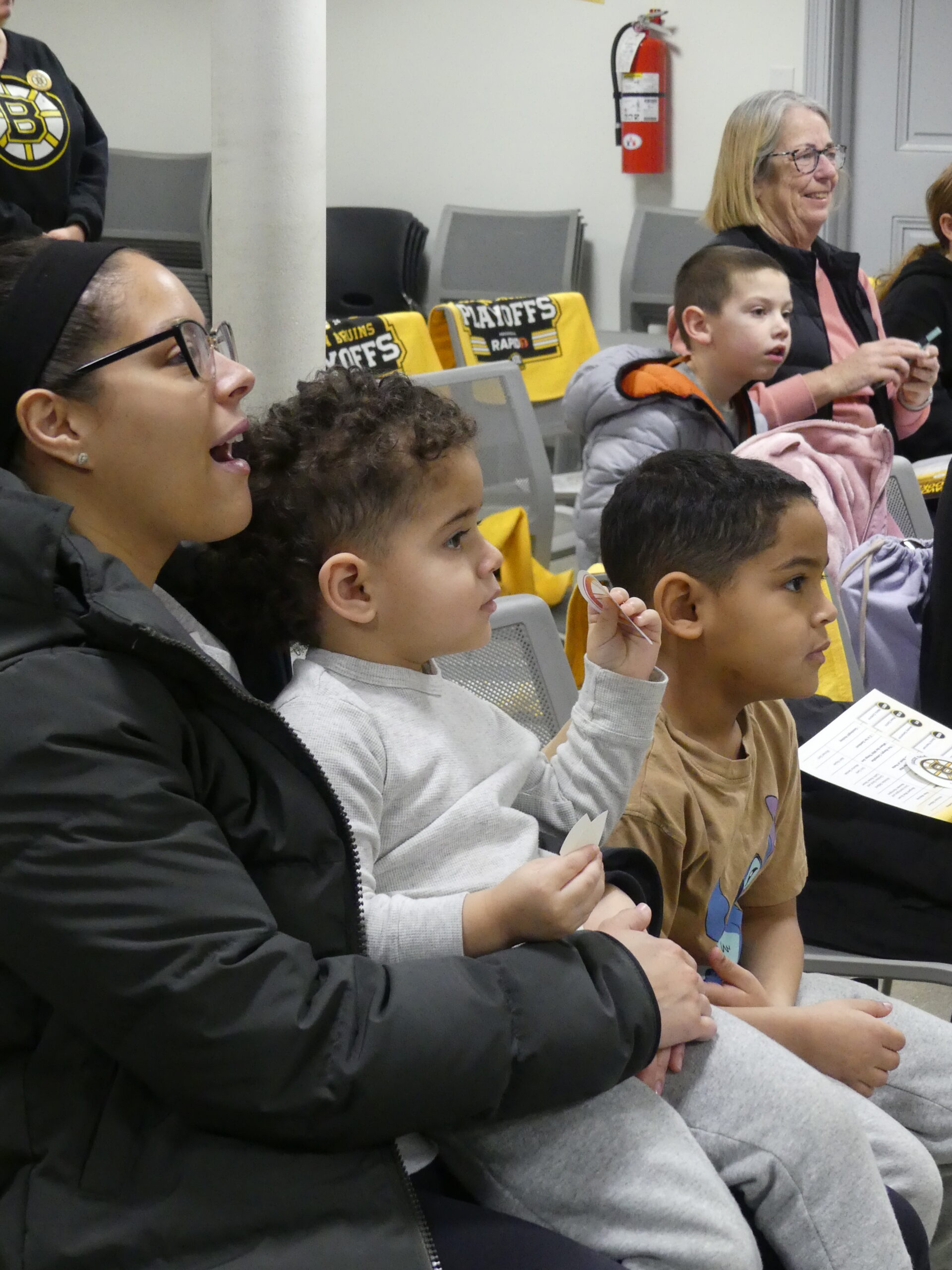 Families sit together and listen to Bruins mascot Blades story time.