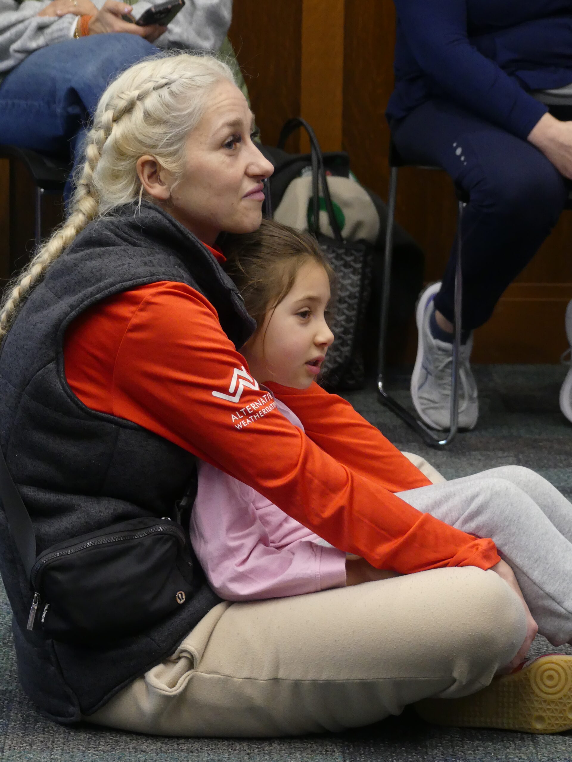 Caregiver and child sit comfortably and listen to Bruins Mascot Blades story time
